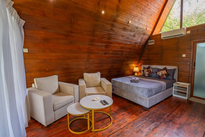 Armchairs and the bed inside the A-frame villa