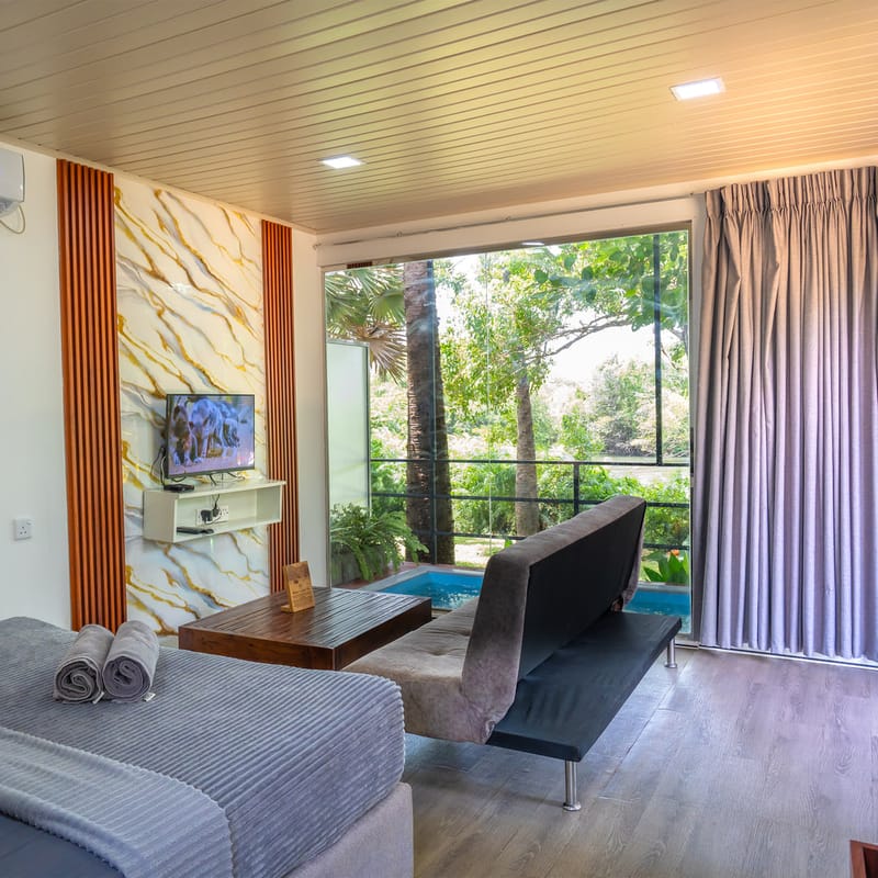 A Wilpattu villa bedroom with the private plunge pool beyond the glass