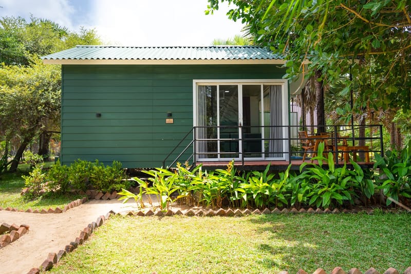 The green cabin's deck and glass doors, set in the garden